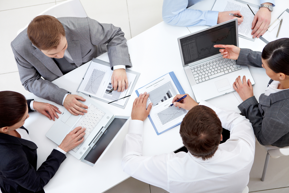 men looking at charts and laptops